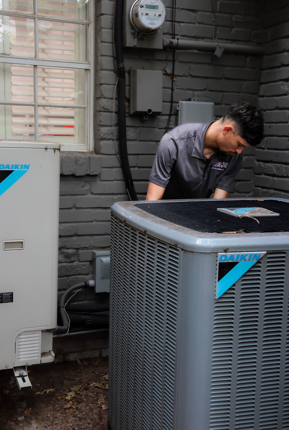 An R&R Air Conditioning employee working to replace an AC unit at a home