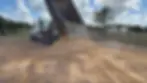 Dump truck delivering base material for new horse arena construction in Hockley, Texas