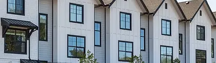 Exterior of white apartment complex with modern vertical siding.