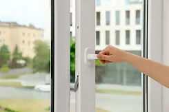 Hand opening a casement window.