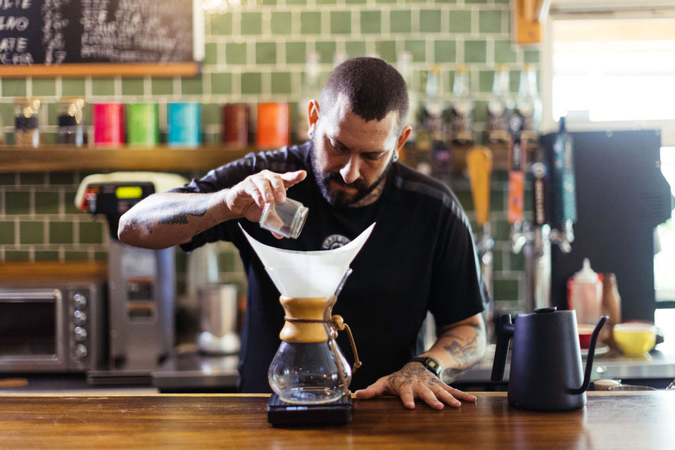barista making a pour over coffee