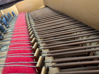 Bass strings and agraffes in a grand piano