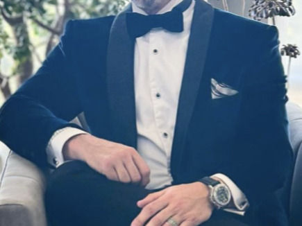 A gentleman in a suit and tie in a car.