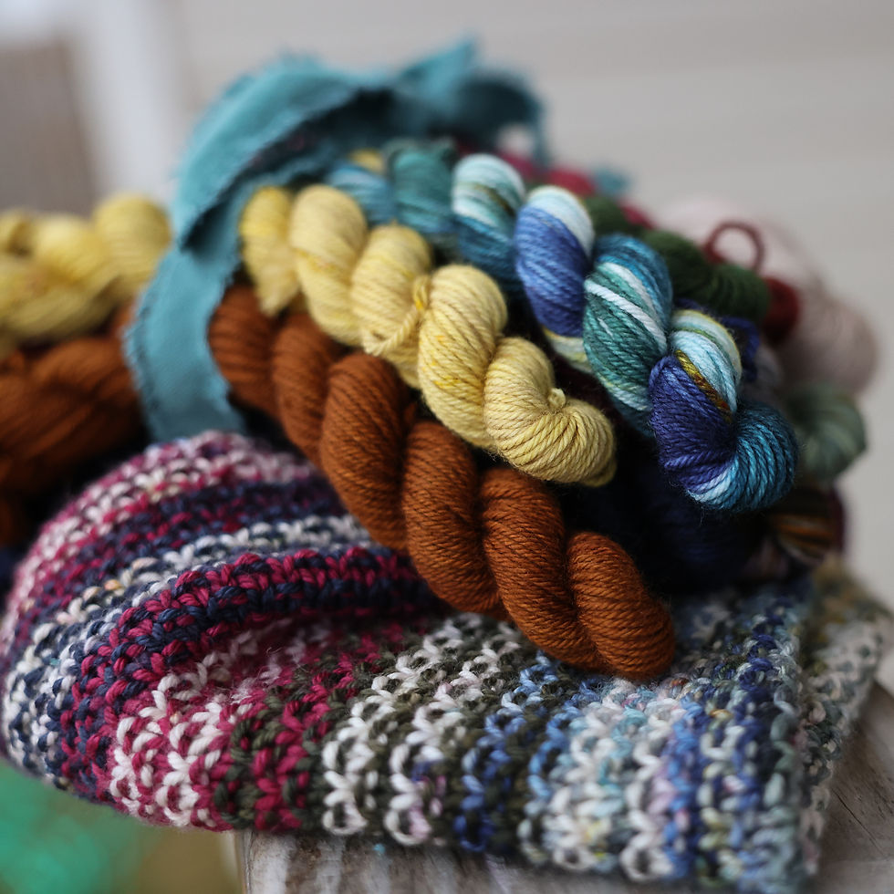 Thumbnail: Mini skein advent yarn stacked on the striped cowl knitting pattern in colorful textures