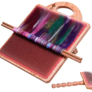 An Ashford blending board with a purple rolag in the process of being rolled