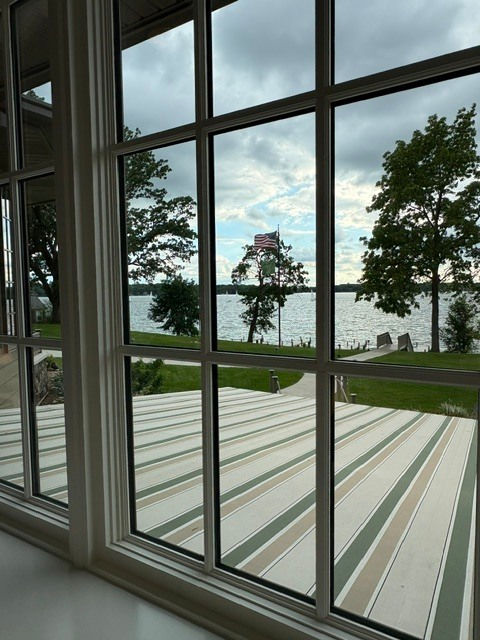 View from a high value lake home through large windows toward the water