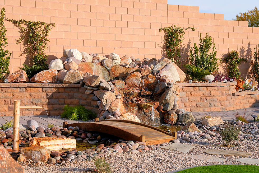 A serene Asian-inspired garden featuring a rock waterfall, delicate bamboo fountain, and a charming wooden bridge, all nestled within a harmonious blend of stones and greenery.