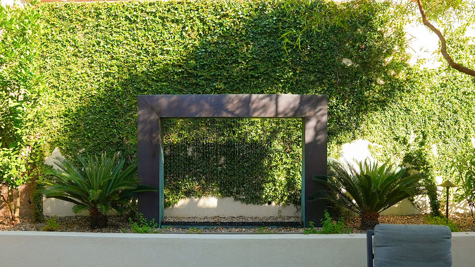 A sleek, ultra-modern fountain blends seamlessly into a verdant garden wall, framed by lush foliage and contemporary design.