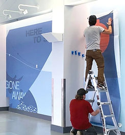 Andresen Technicians installing a large banner on a wall