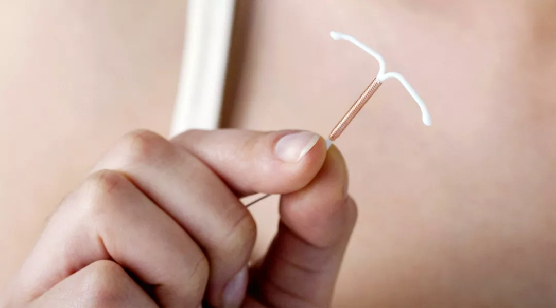 doctor holding intrauterine birth control device IUD
