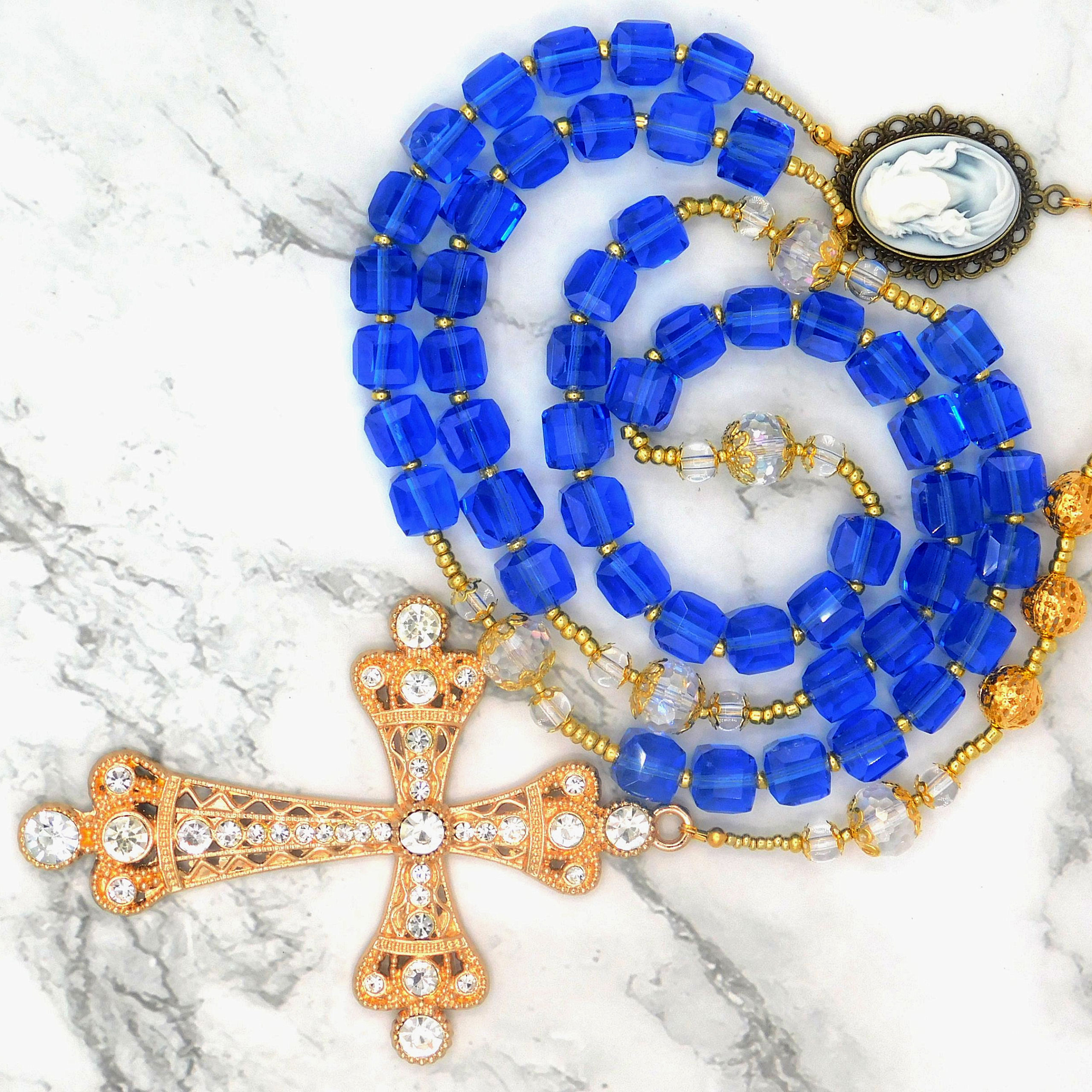 "Elegant blue crystal rosary with a gold-plated, jewel-encrusted cross and a vintage cameo medallion