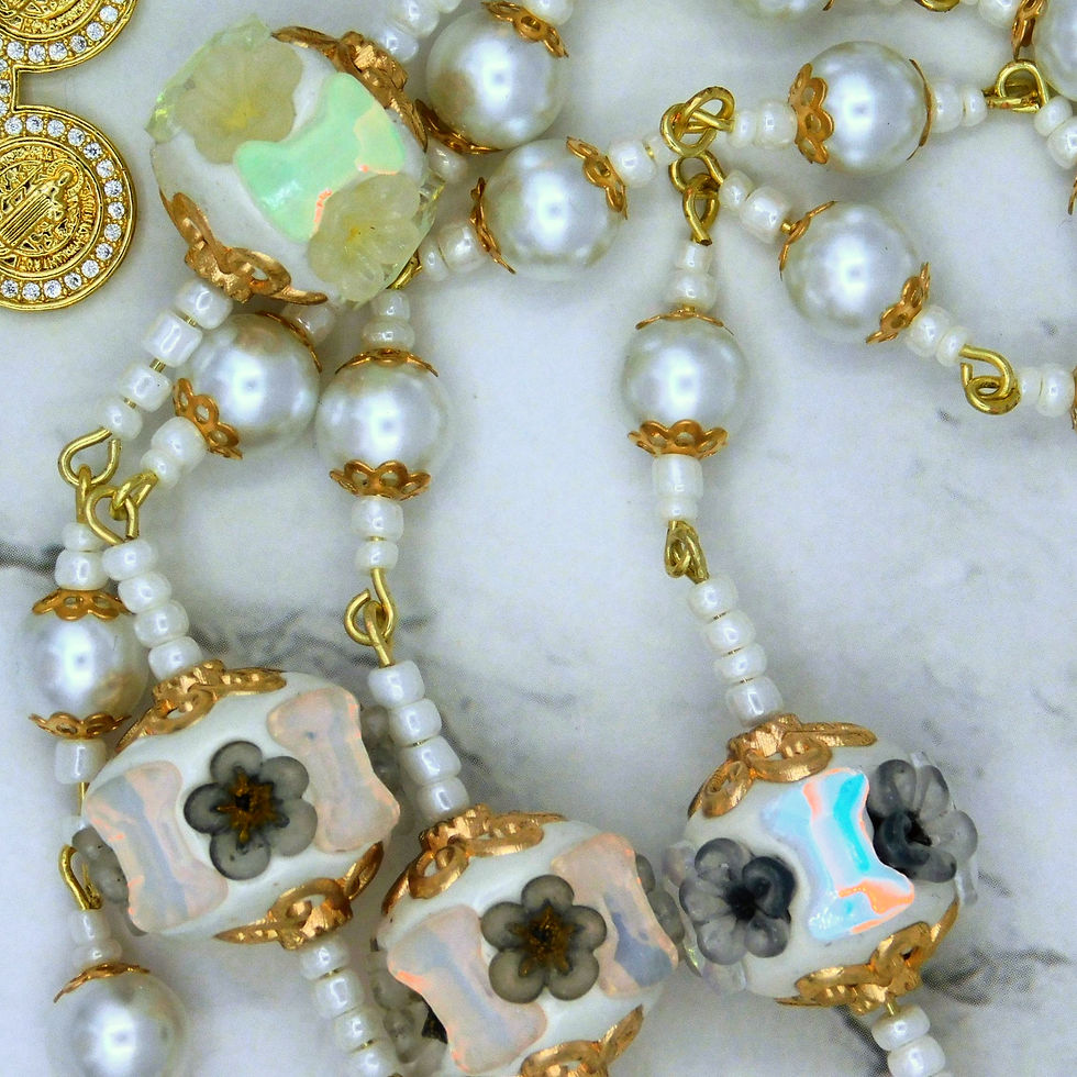 Thumbnail: Elegant Catholic rosary with white pearl beads, gold accents, floral ceramic Our Father beads, and a decorative gold crucifix