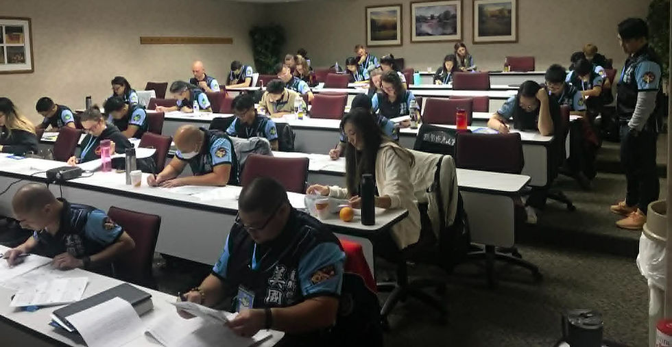 People in uniforms focus on paperwork in a conference room with maroon chairs and framed art. Mood is serious and attentive.