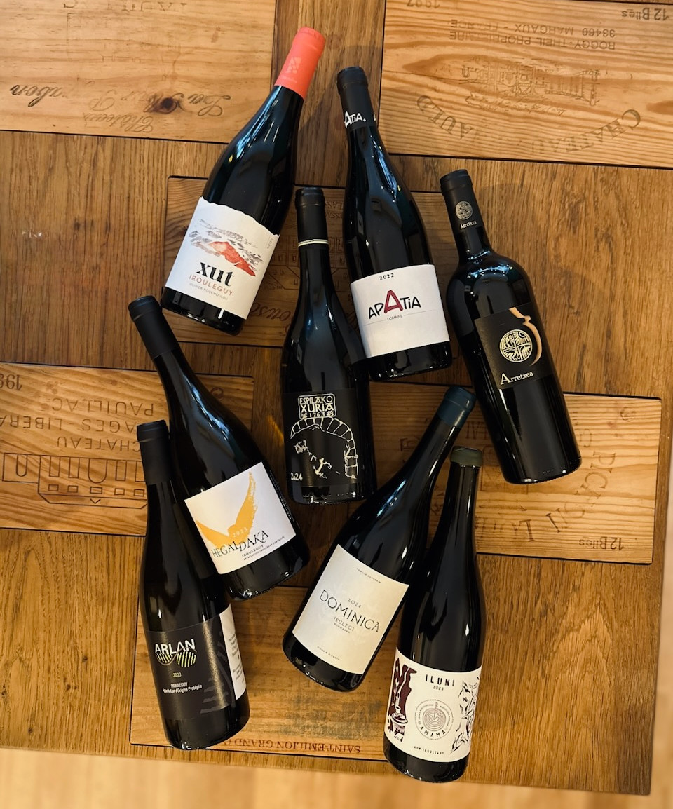 bouteilles de vin rouges posées à plat sur une table en chêne