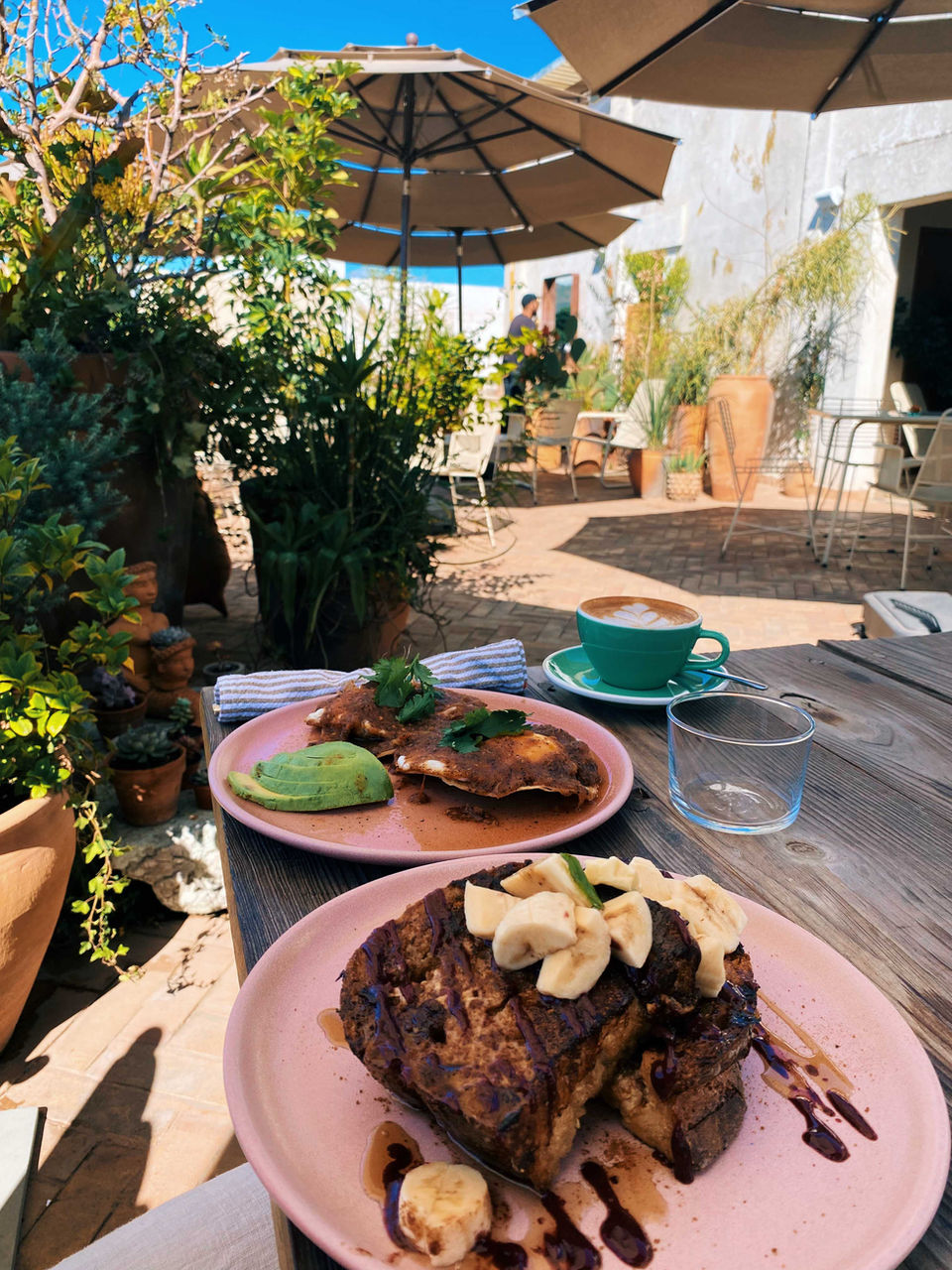 Outdoor café brunch in Oaxaca with pancakes, coffee, and greenery