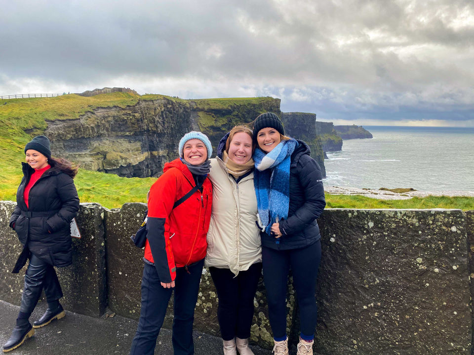Friends posing at the Cliffs of Moher in Ireland