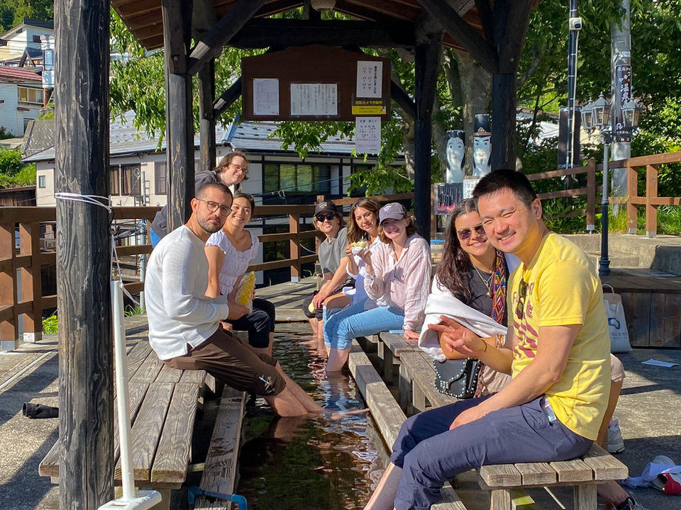 Group of FTLO travelers relaxing at a Japanese foot bath hot spring.