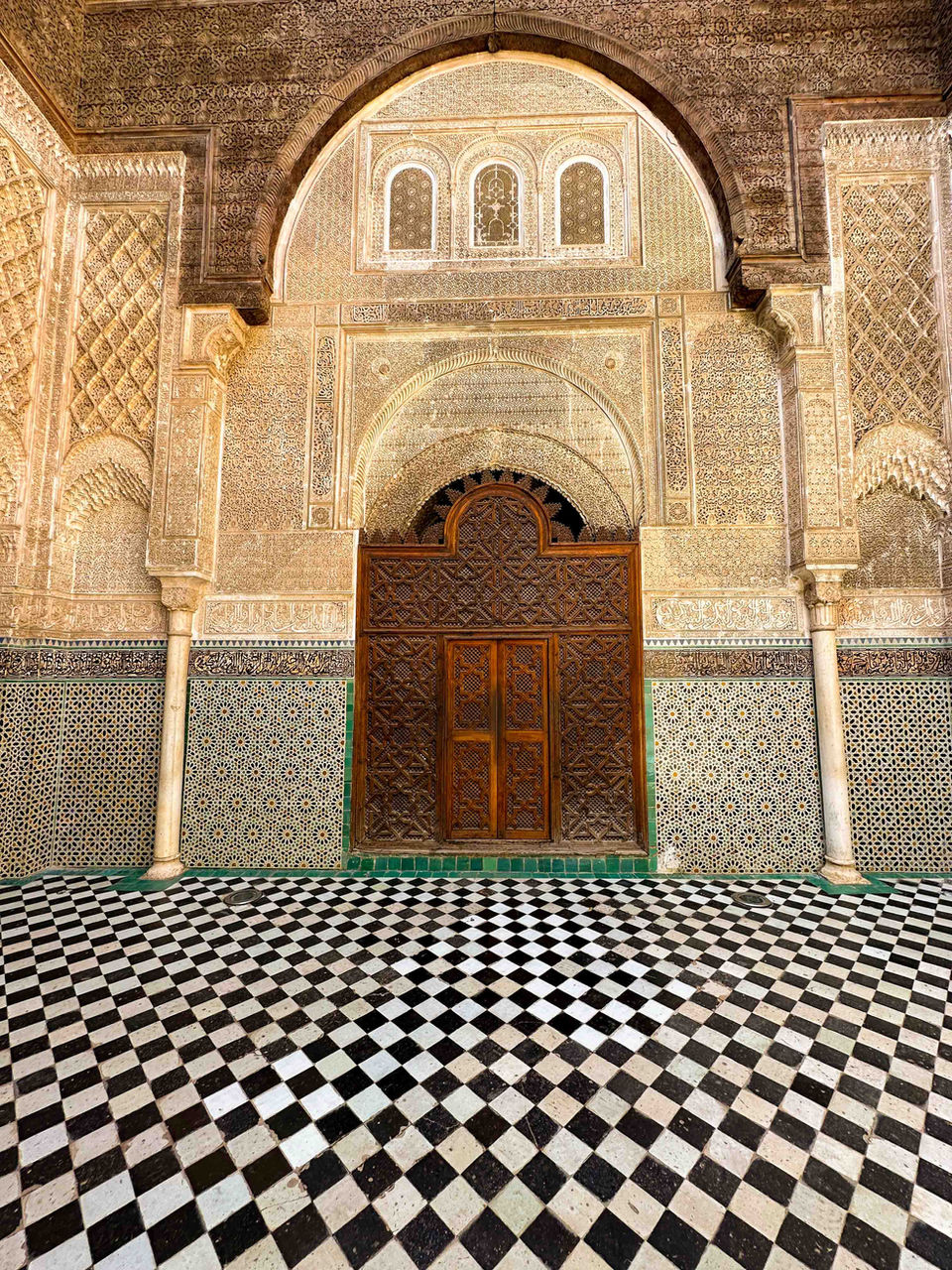 Ornate arched doorway at a historic Moroccan mosque or madrasa