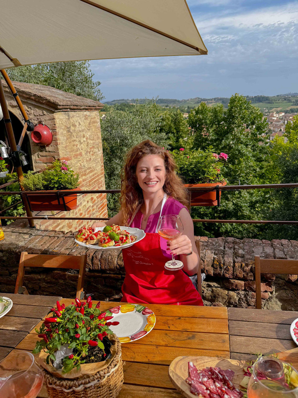 Solo traveler enjoying dinner outdoors with Tuscan views in the background