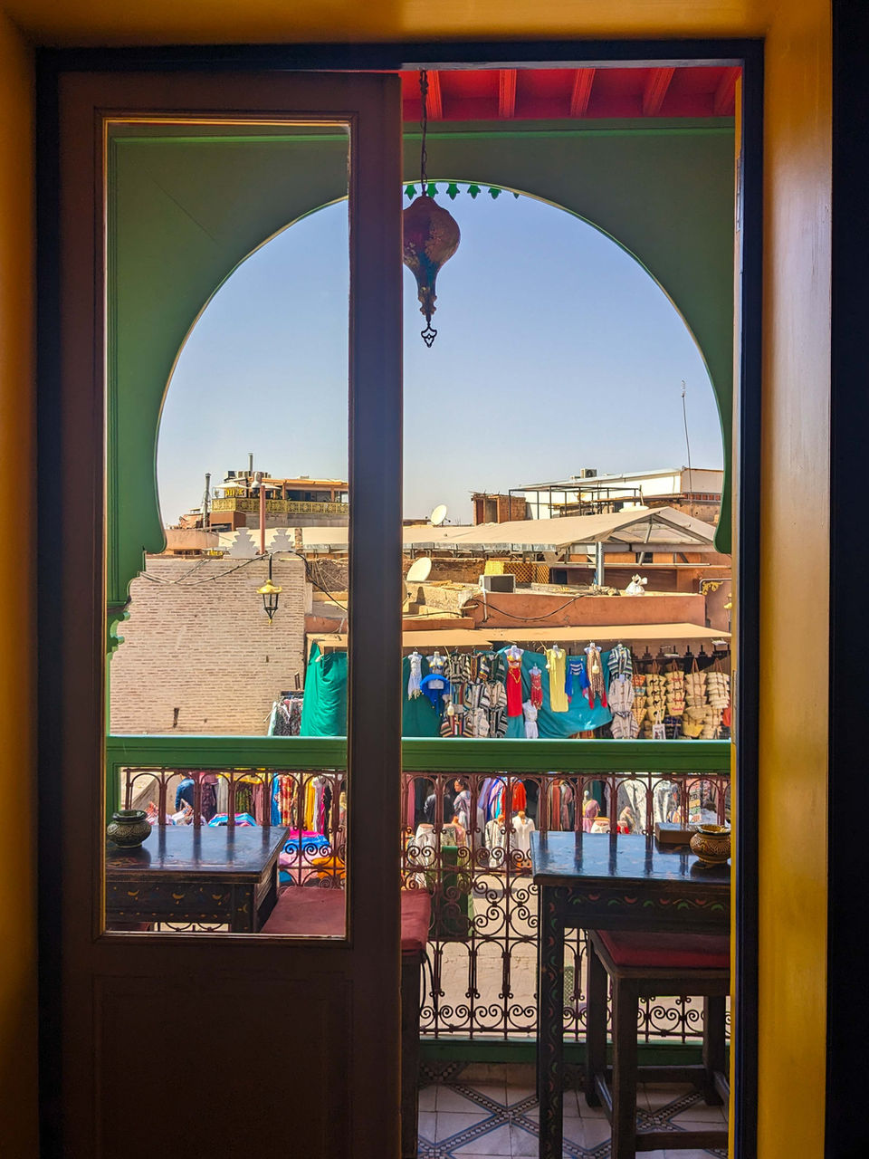 View of Marrakesh rooftops and souks framed by a colorful arched window