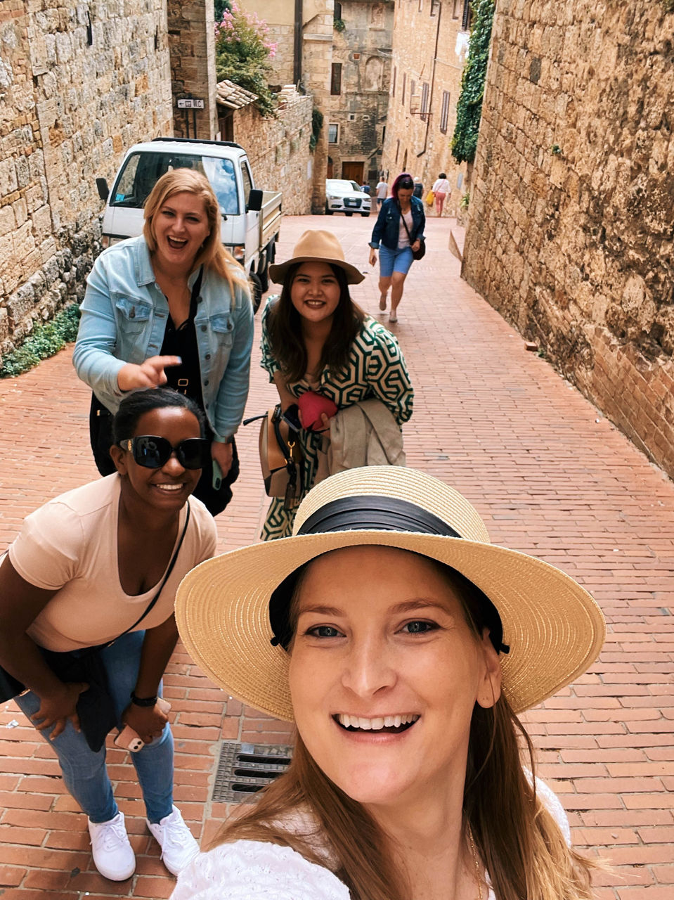 Friends walking down a cobblestone street during an FTLO Tuscany trip