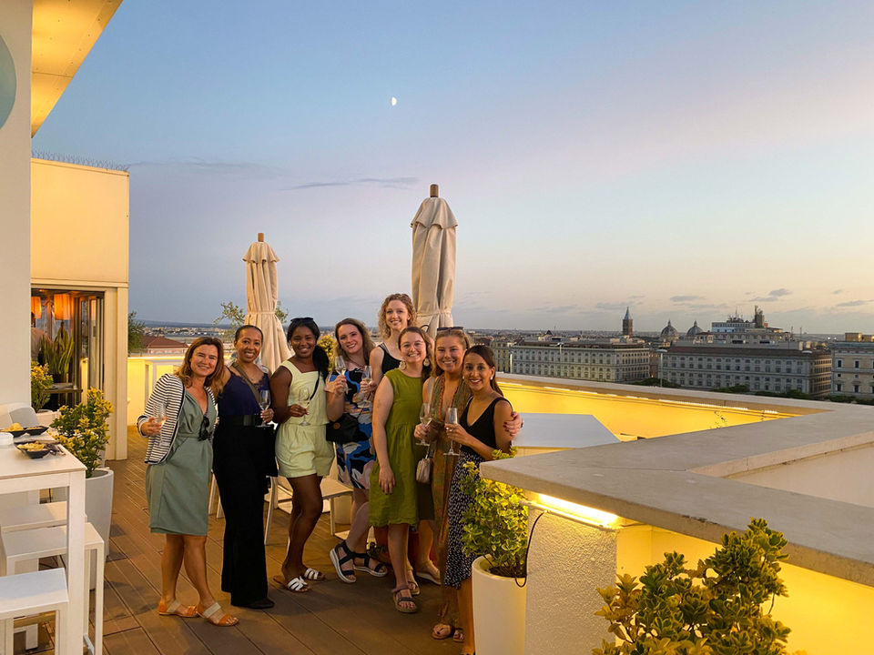 Group photo of travelers on a rooftop terrace in Rome at sunset