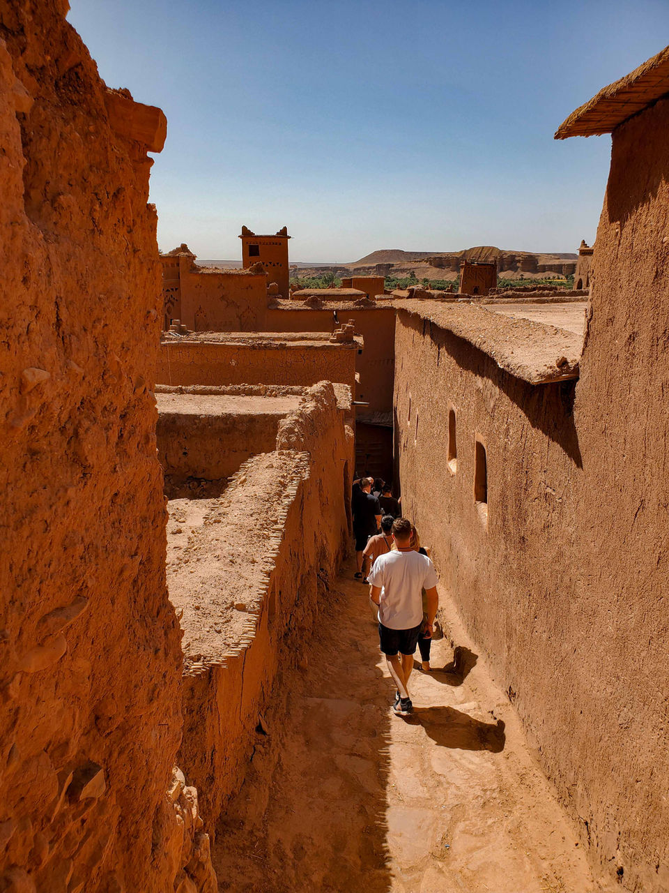 Narrow alley with traditional mudbrick walls in a Moroccan desert village
