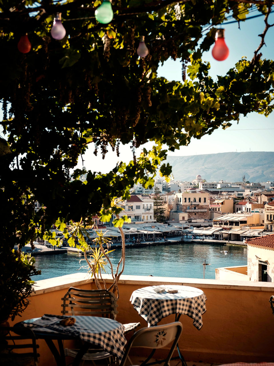 Shaded café terrace overlooking the harbor in Crete.