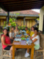 Young travelers in Bali smiling as they sit to eat together outdoors