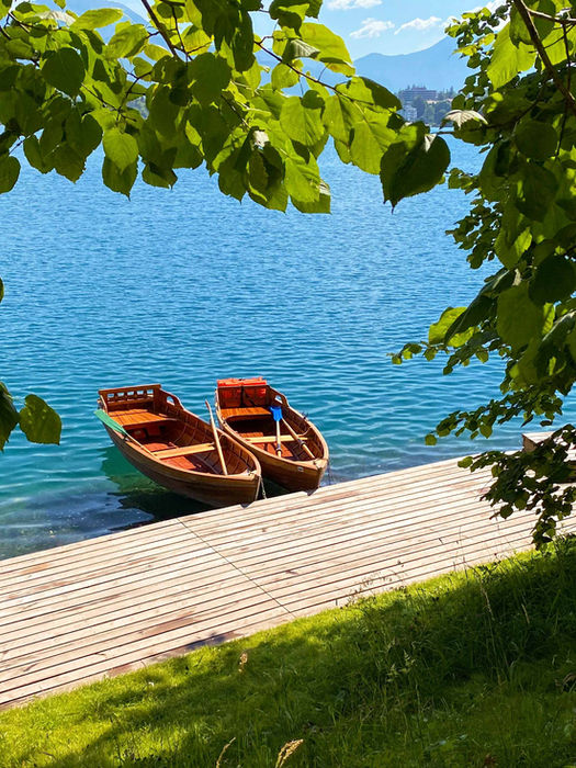 Two rowboats docked along the shore of Lake Bled, Slovenia.