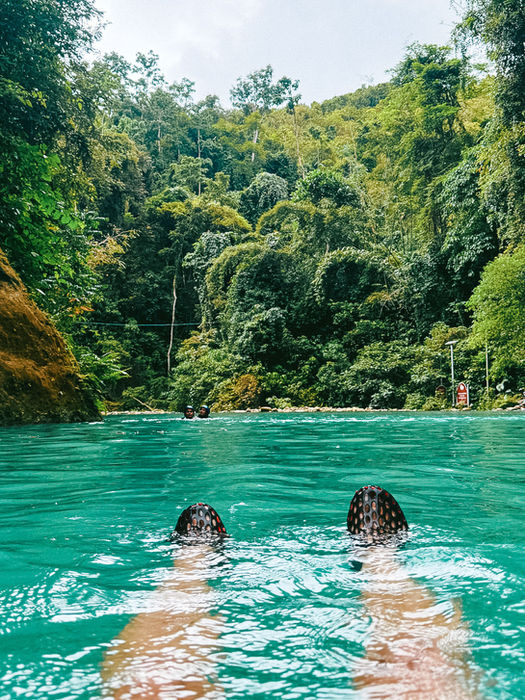 Floating in turquoise water surrounded by jungle in the Philippines