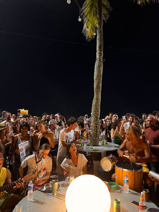 Crowd gathered at night for live samba music on the beach in Rio