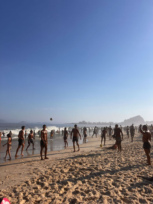 Crowds playing beach volleyball and soccer in Brazil