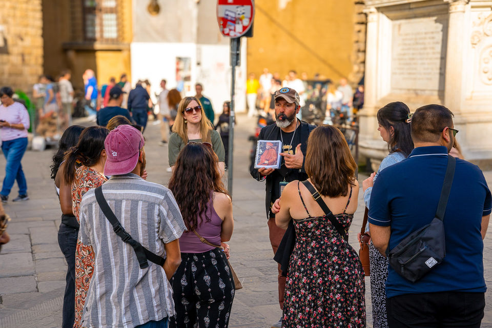 Travel group listening to a local guide during a city walking tour in Italy