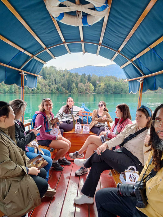 Group of travelers riding a pletna boat on Lake Bled.