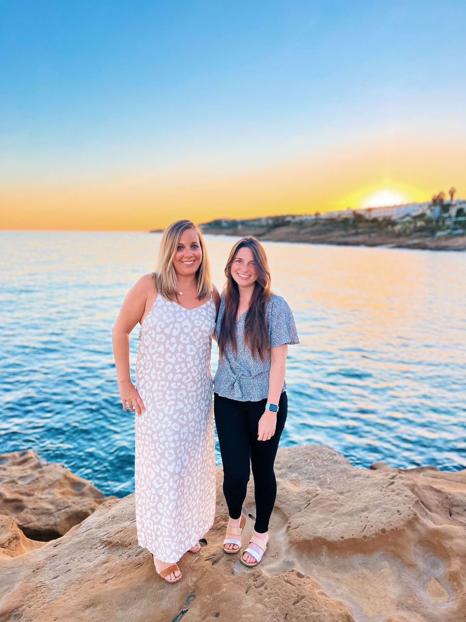 Two young professionals posing by the water on a trip to Portugal