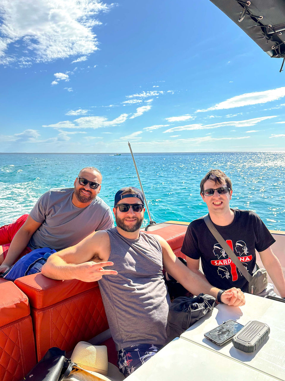 Friends relaxing on a boat under sunny Sardinian skies.