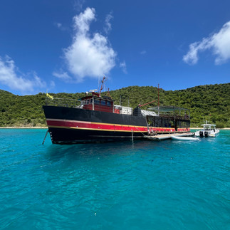 The legendary floating bar and restaurant Willy T anchored off Norman Island in the British Virgin Islands, where guests dive off the deck and boats moor nearby.