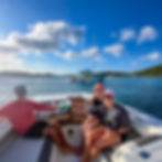 Group of friends enjoying drinks and pizza on a private boat charter near Pizza Pi St. John USVI showing fun social boating experience in the Virgin Islands