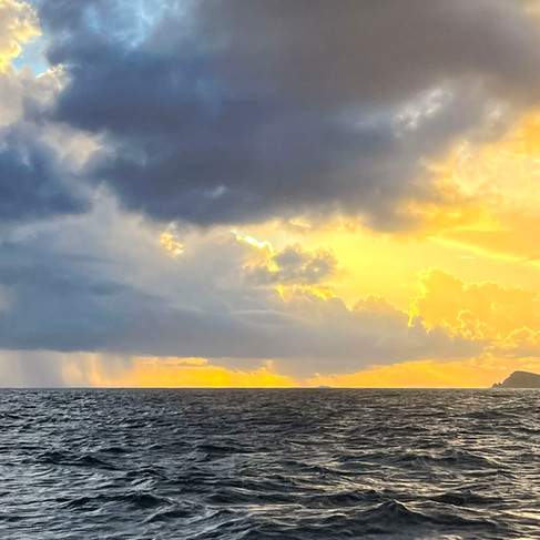 Isolated rain shower over Caribbean water in the Virgin Islands, demonstrating scattered tropical weather conditions