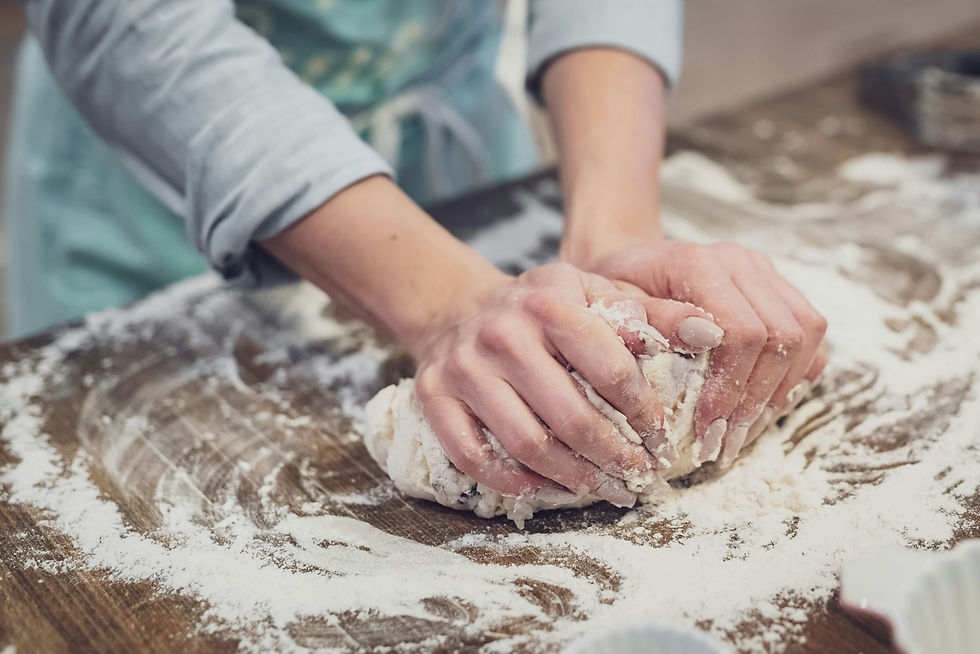 a woman's hands kneading dough on a floured board