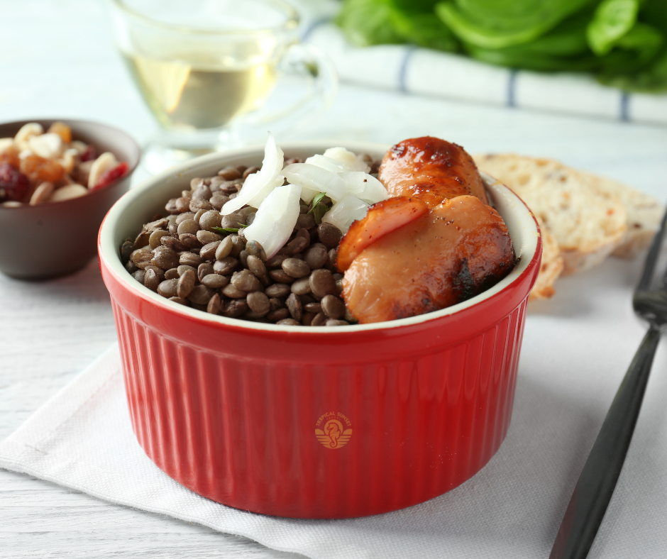 A red ramekin bowl with lentils and sausage