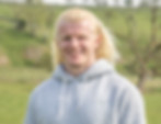 Smiling man in gray hoodie, outdoors