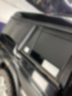 Black SUV side profile with dark tinted windows and roof rack.