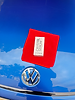 Crystal Serum product on a red cloth with Volkswagen logo on blue car