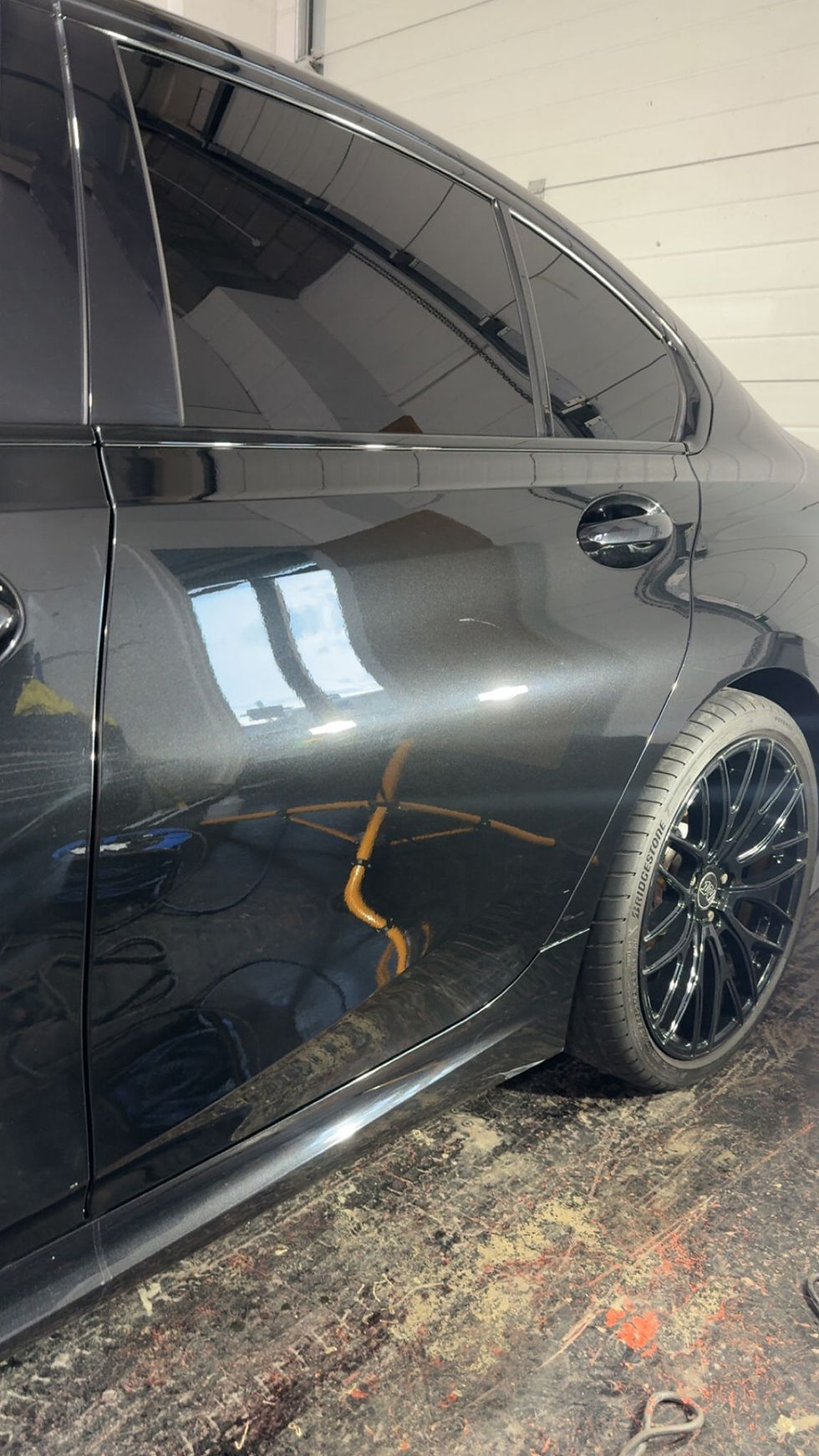 Black sedan with damage to side door