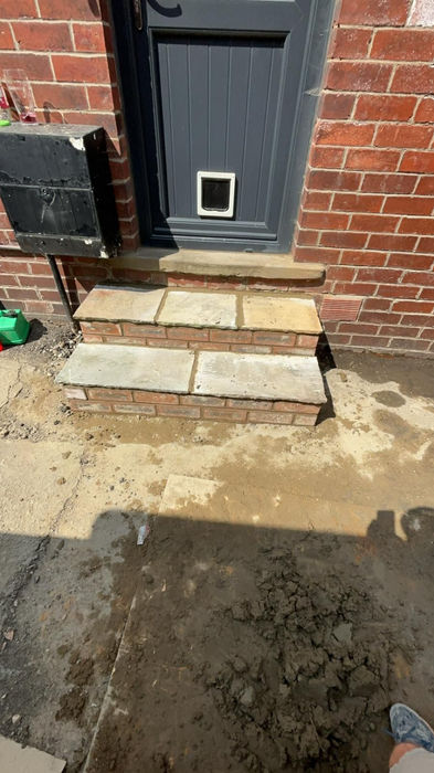 Brick steps leading to a door with a pet door