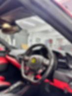 Red and black Ferrari car interior with steering wheel