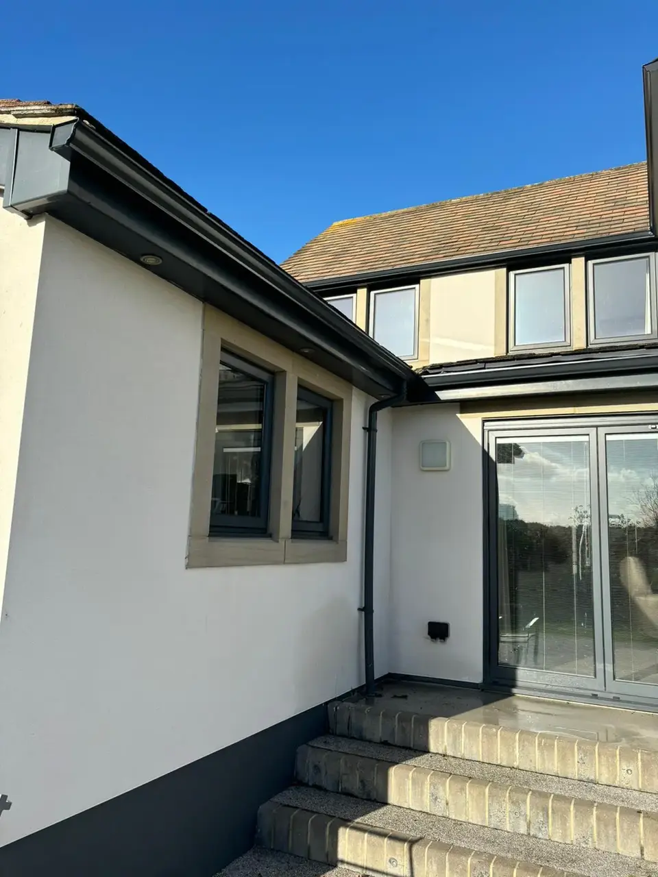 Grey seamless gutters on house exterior