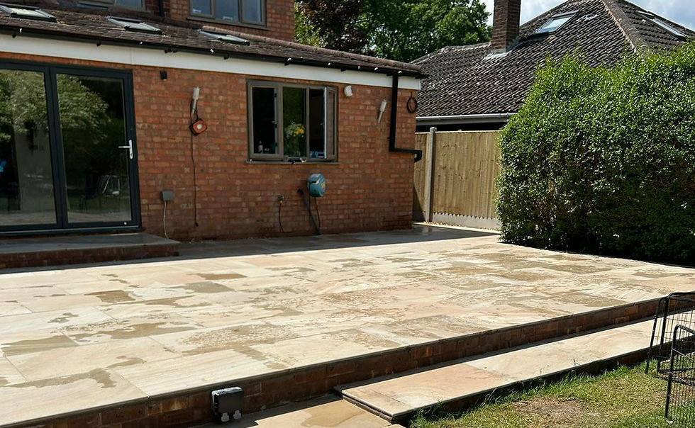 Newly installed patio with a beautiful home on a sunny day.